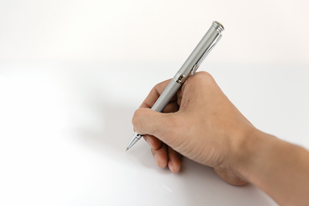 Close up of man hand writing with metallic pen on white backgroundの写真素材