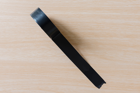 Black adhesive tape on wooden backgroundの写真素材