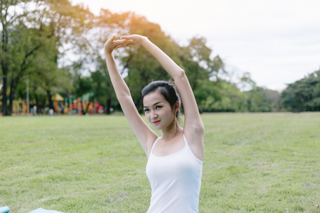 Woman do yoga and relaxation in garden. Woman exercising vital and meditation for fitness lifestyle at the nature background. Concept Yogaの写真素材