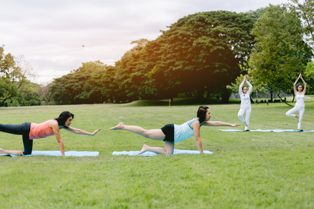 Woman do yoga and relaxation in garden. Woman exercising vital and meditation for fitness lifestyle at the nature background. Concept Yogaの写真素材