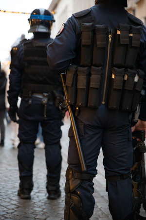 Close-up of a police officer in a blue uniform with a gun.
