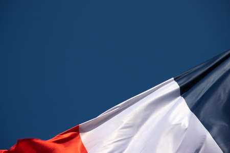 Flag of France waving in the wind on a blue sky background.の写真素材