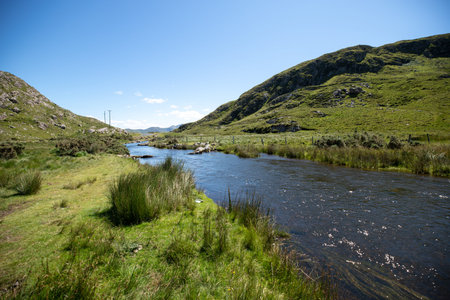 A view of a small river flowing through the hills of Ireland.