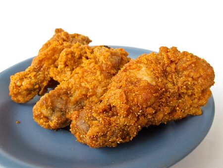 Spicy fried chicken on the blue dish with white backgroundの写真素材