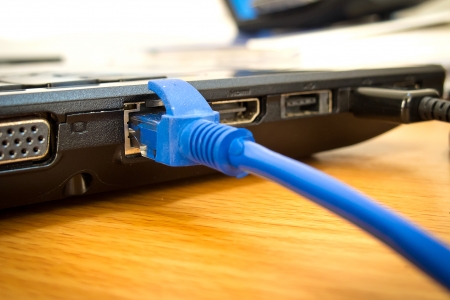 Blue UTP network cable connecting to laptopの写真素材