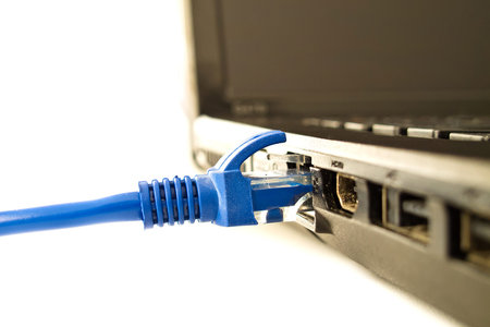 Blue UTP network cable connecting to laptop