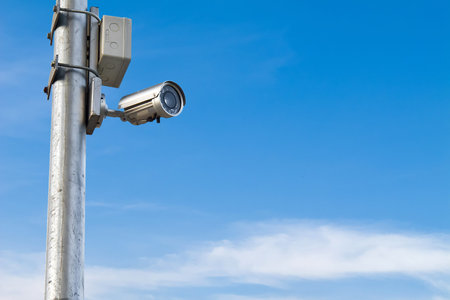 Security CCTV camera isolated on blue sky background