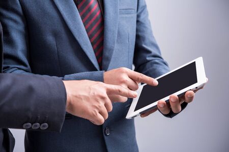 Image of two businessmen using tablet at meetingの写真素材