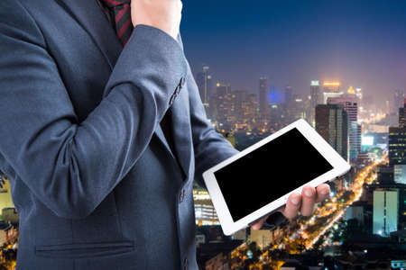 business man using a touch screen device with city nightの写真素材