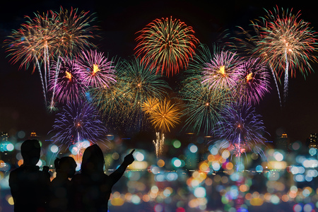 happy family looking Beautiful colorful fireworks on celebration nightの写真素材
