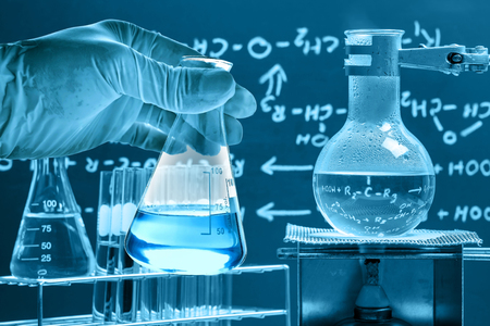 Flask in scientist hand with laboratory backgroundの写真素材