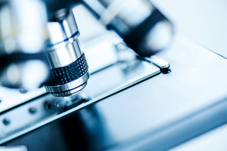 Microscope with lab glassware and dropping chemical liquid to test tube in chemical laboratory...