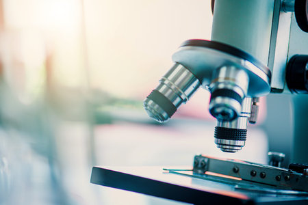 Microscope with lab glassware and dropping chemical liquid to test tube in chemical laboratory...