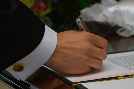 Close up on the groom signing the wedding documents