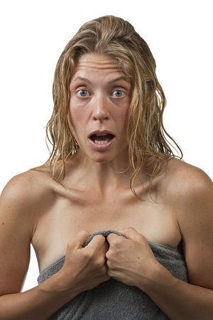 Closeup on blond woman with curly hair who's surprised while getting out of the shower, and grabs her towel.の写真素材