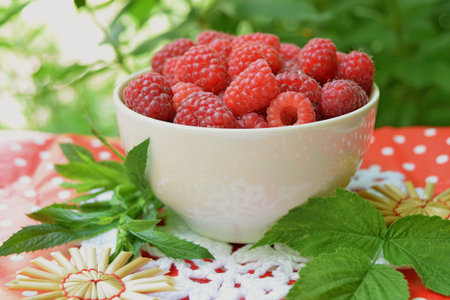 Ripe raspberry in cup Compositions with mint leaves and raspberries.