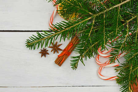 Christmas Holiday Background with Gingerbread cookies, Candy Cane and evergreens border over wooden table. Christmas and New year food. Christmas decoration and sweets on light wood background.の写真素材