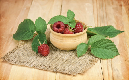 Raspberries in a wooden bowl. raspberries on the old wooden table. Copy space.