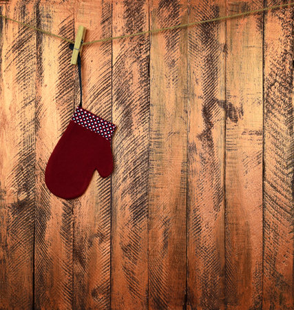 Children's mitten on a rope. Christmas miracle. Waiting for Santa. Christmas background. Wooden planks. Tradition and childhood. New Year.の写真素材