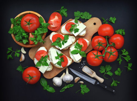 A sandwich with tomatoes and cheese. Italian traditional bruschetta with tomatoes on a rustic table.Top view. Flat-lay. A dark wooden backgroundの写真素材