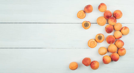 Ripe apricots on rustic background. apricots with leaves on wooden background. Ripe apricots with copy space for text. Various fresh summer fruits. Apricots on a wooden table. Top view.の写真素材