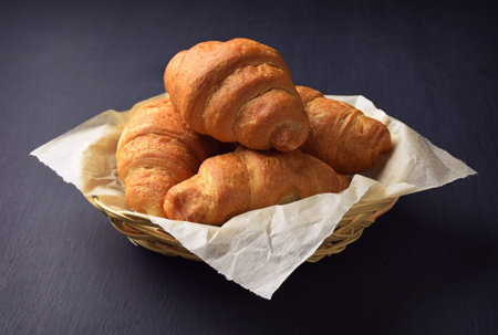 croissant on the table. Croissant close-up on a black background. Pieces of chocolate and fresh...