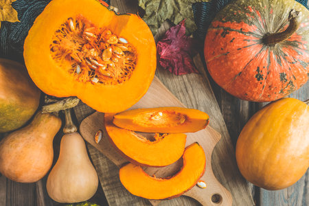Pumpkins on the table. Autumn Background. Halloween party. Thanksgiving day. Halloween decor with various pumpkins, autumn vegetables and flowers. Harvest and decoration.Thanksgiving day concept.の写真素材