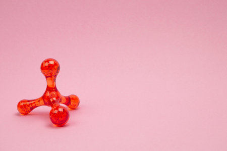 Side view of a hand massager on a light pink background, promoting relaxation and self-care. Copyspace.の写真素材