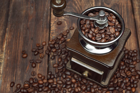 Aromatic coffee beans and a coffee grinder on an old wooden table. Top view. Good morning concept. Copyspaceの写真素材