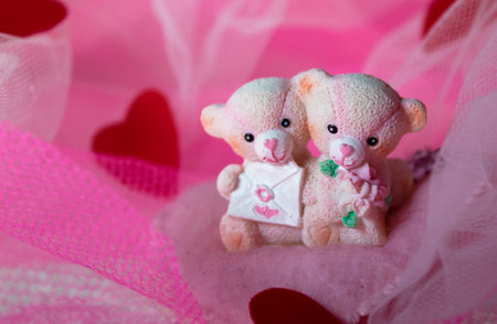 souvenir teddy bears on a pink textile background with hearts and flowers for Valentine's dayの写真素材