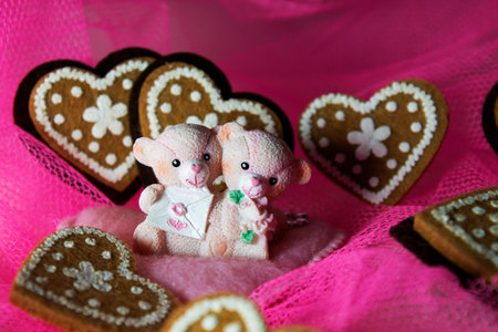 souvenir teddy bears on a pink textile background with hearts and flowers for Valentine's dayの写真素材