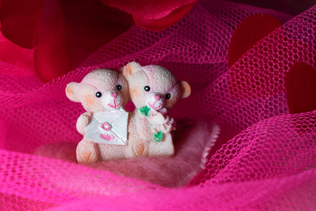 souvenir teddy bears on a pink textile background with hearts and flowers for Valentine's dayの写真素材