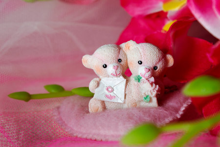 souvenir teddy bears on a pink textile background with hearts and flowers for Valentine's dayの写真素材