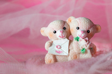souvenir teddy bears on a pink textile background with hearts and flowers for Valentine's dayの写真素材