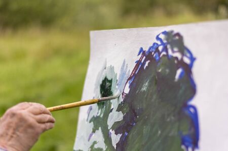 Drawing oil paintings of a natural landscape on a white cardboardの写真素材