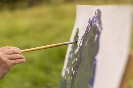 Drawing oil paintings of a natural landscape on a white cardboardの写真素材