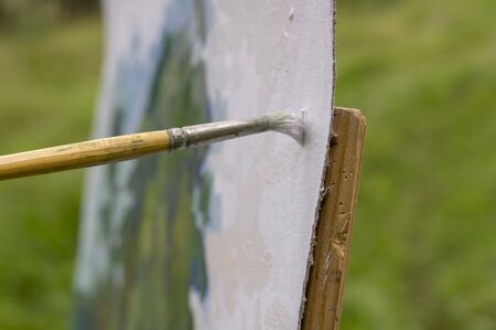 Drawing oil paintings of a natural landscape on a white cardboard. Happiness, hobbies.の写真素材