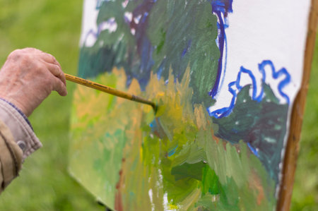 Drawing oil paintings of a natural landscape on a white cardboard. Happiness, hobbies.の写真素材