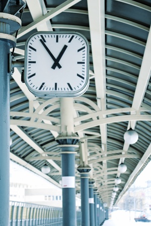 Clock on empty train station in winter. Arrows focused のeditorial素材