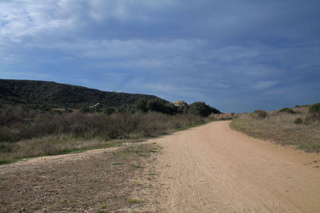 dirt road with gray cloudsの写真素材