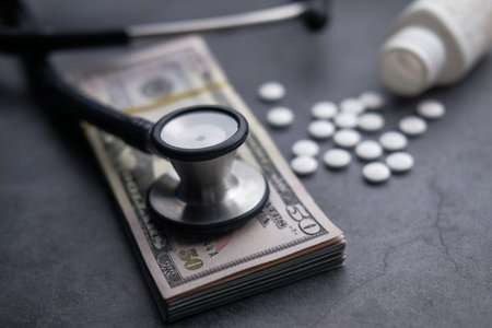 Close up of pill, cash and stethoscope on table