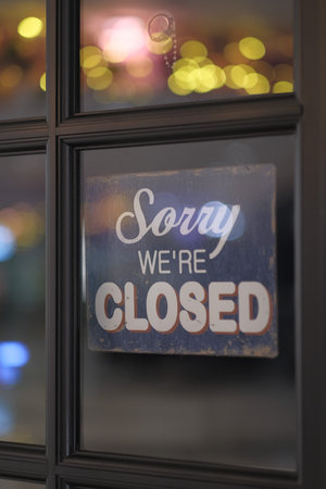 Close up of closing sign on window.