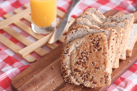 Closeup of brown bread and orange juice on table.