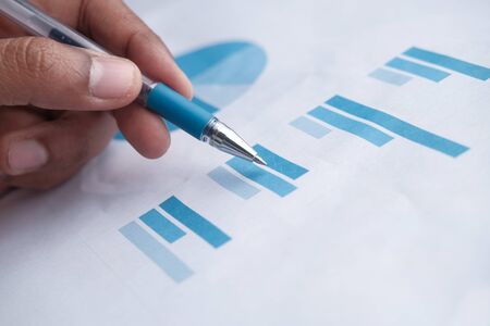 closeup of man hand analyzing bar chart on paper.の写真素材