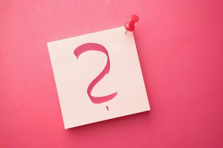 question mark on notepad on red background, top viewの写真素材