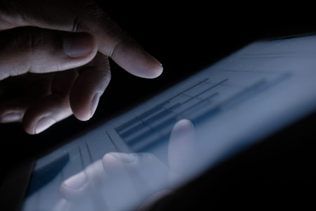 Man hand analyzing chart on digital table at night, close upの写真素材