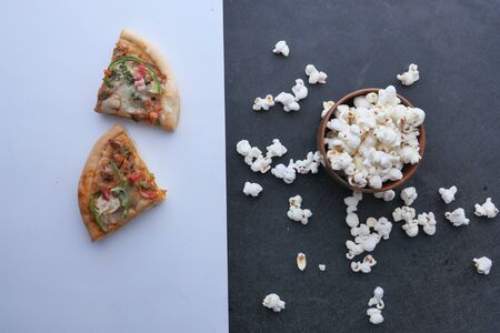 homemade pizza and popcorn in a bowl on table , top view .の写真素材
