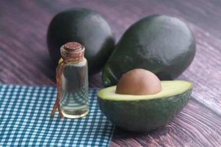 close up of avocado oil with fresh avocado on table .の写真素材