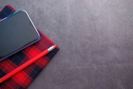 top view of smart phone and notepad on table .の写真素材
