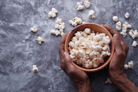 top view of women hand holding popcorn bowl .の写真素材